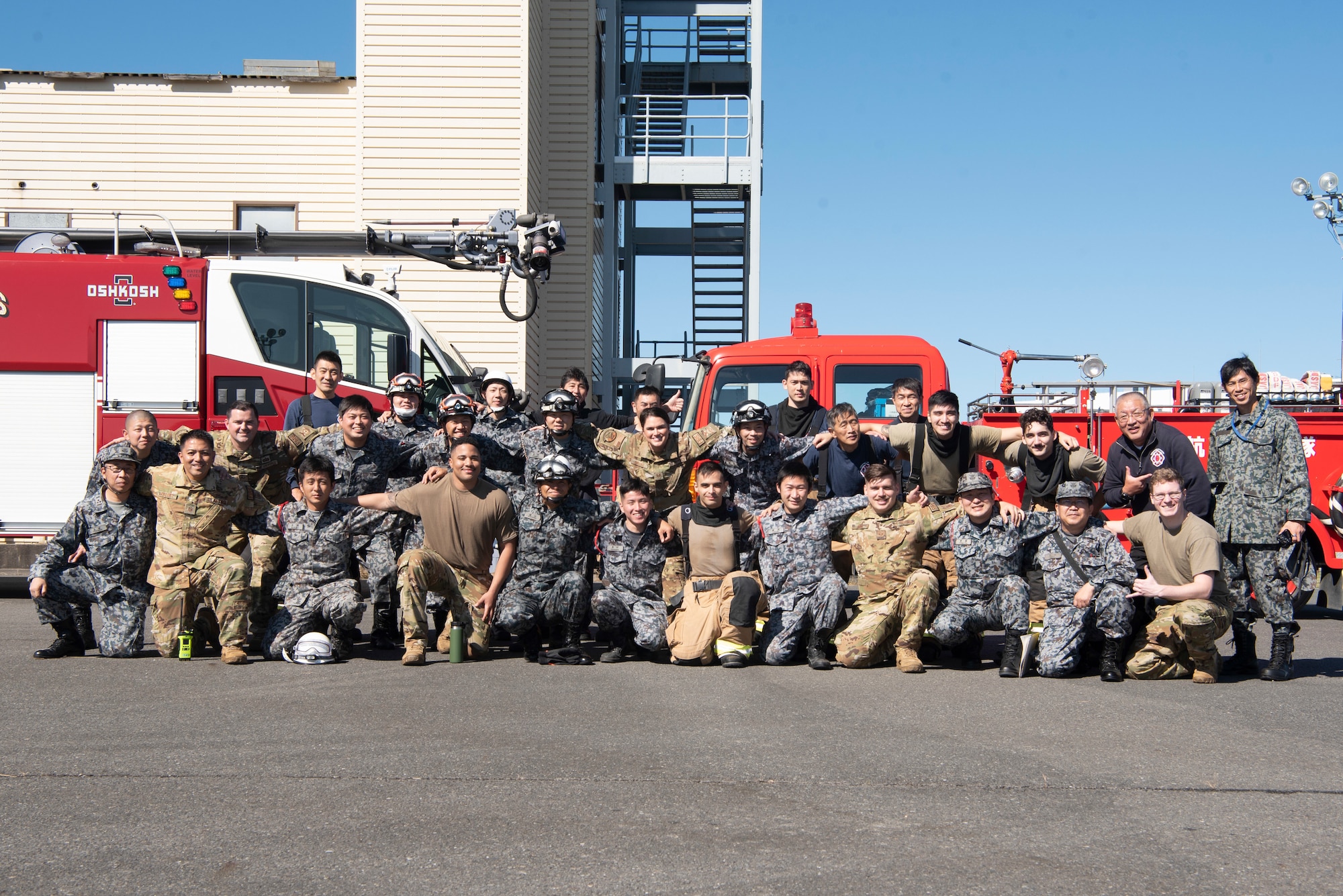 Firefighters from Japanese Air Self-Defense Force and 374th Civil Engineer Squadron pose for a group photo during a bilateral training at Yokota Air Base, Japan, Oct. 26, 2022.