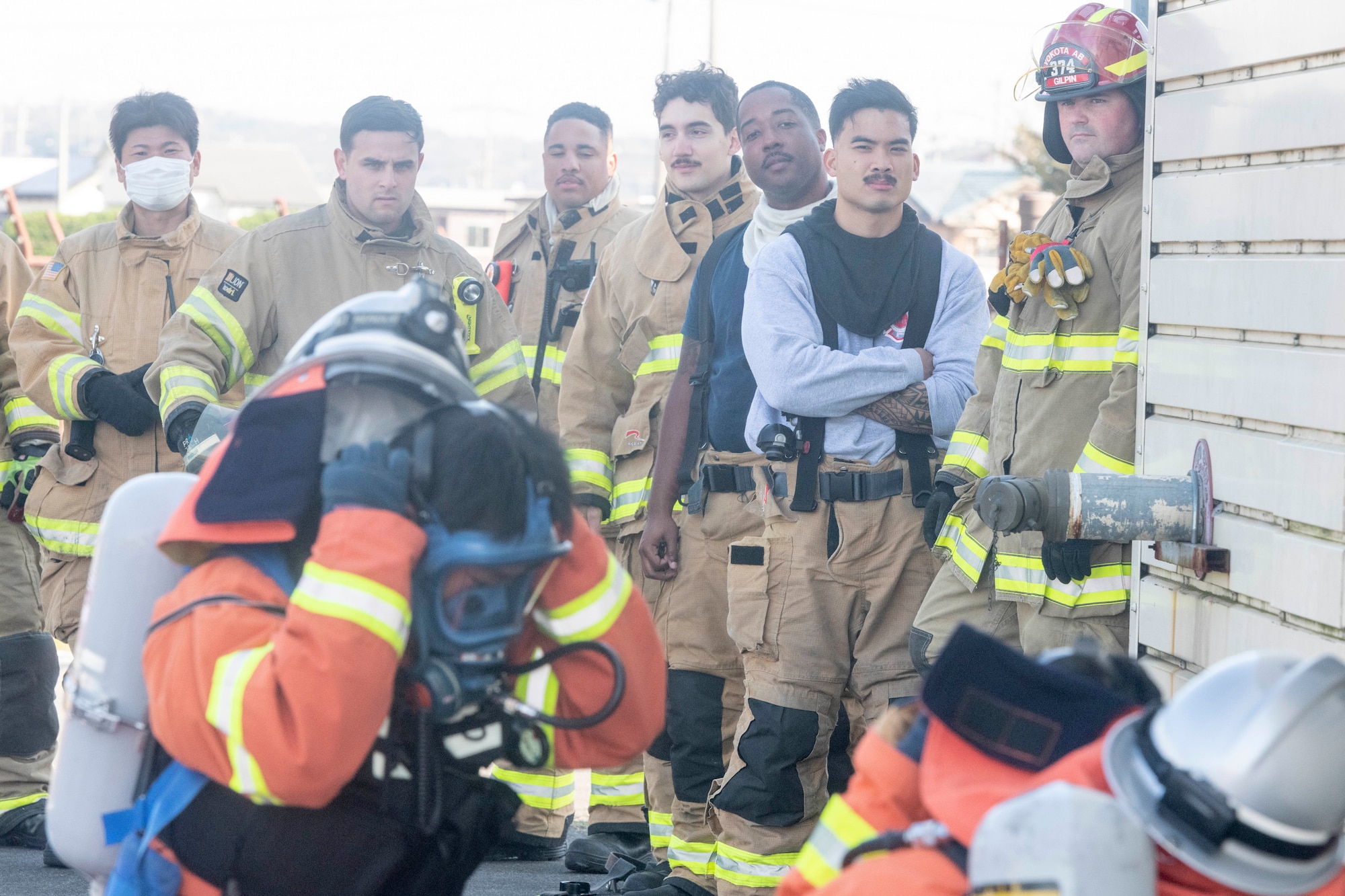 Firefighting Airmen from the 374th Civil Engineer Squadron watch Japan Air Self-Defense Force firefighters demonstrate how to combat a structural fire during a bilateral training at Yokota Air Base, Japan, Oct. 28, 2022.