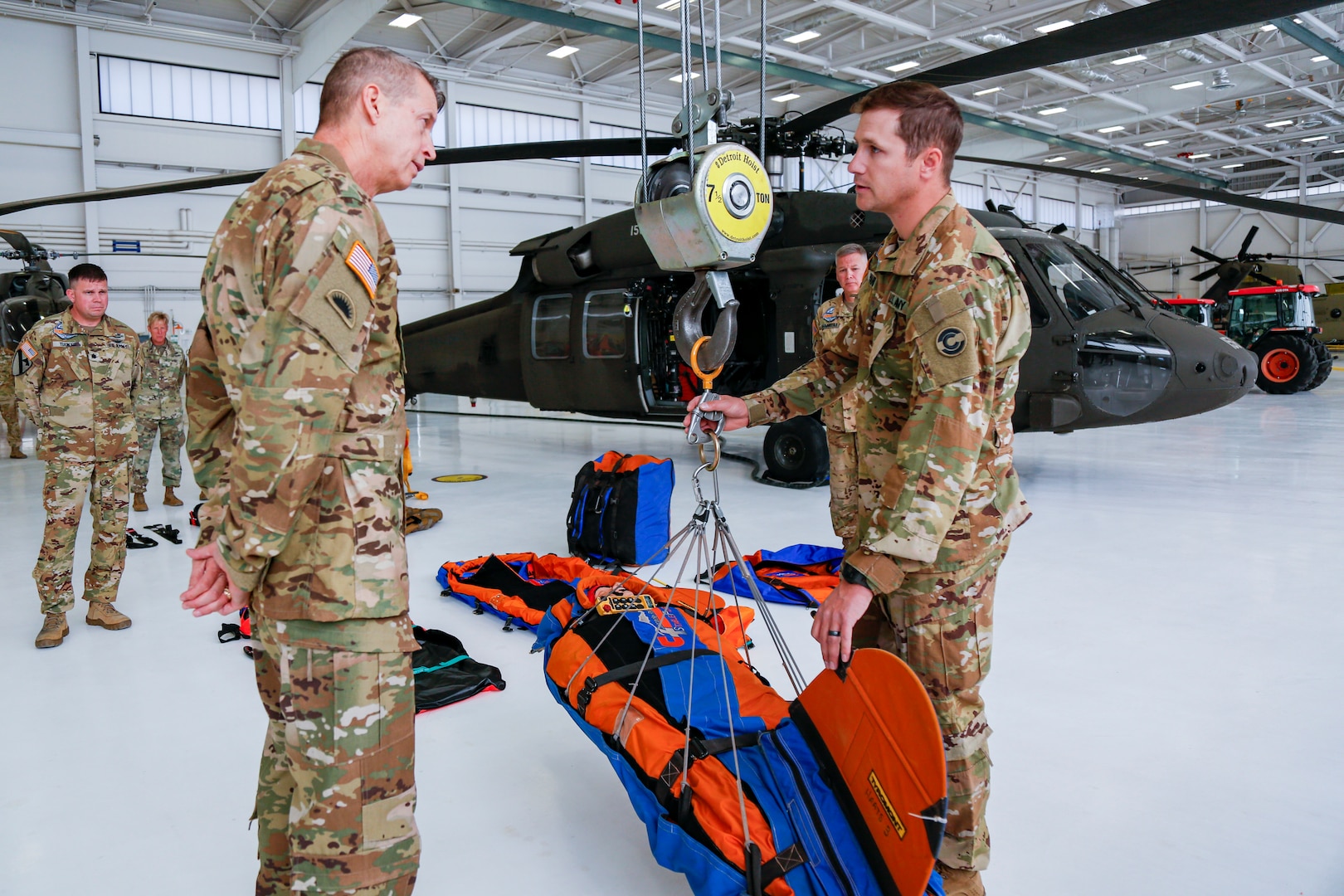 Army Gen. Daniel Hokanson, chief, National Guard Bureau, left, talks with Staff Sgt. Jeremy Hubbard, a crewmember flight instructor and Black Hawk mechanic, about the equipment the Colorado National Guard uses during airlift rescues on a visit to the Colorado National Guard's High-altitude Army National Guard Aviation Training Site, or HAATS, in Gypsum, Colorado, Oct. 16, 2022. HAATS is facilitated by Colorado Guardsmen and designed to train military pilots from any branch in power management and operating in high-altitude environments.