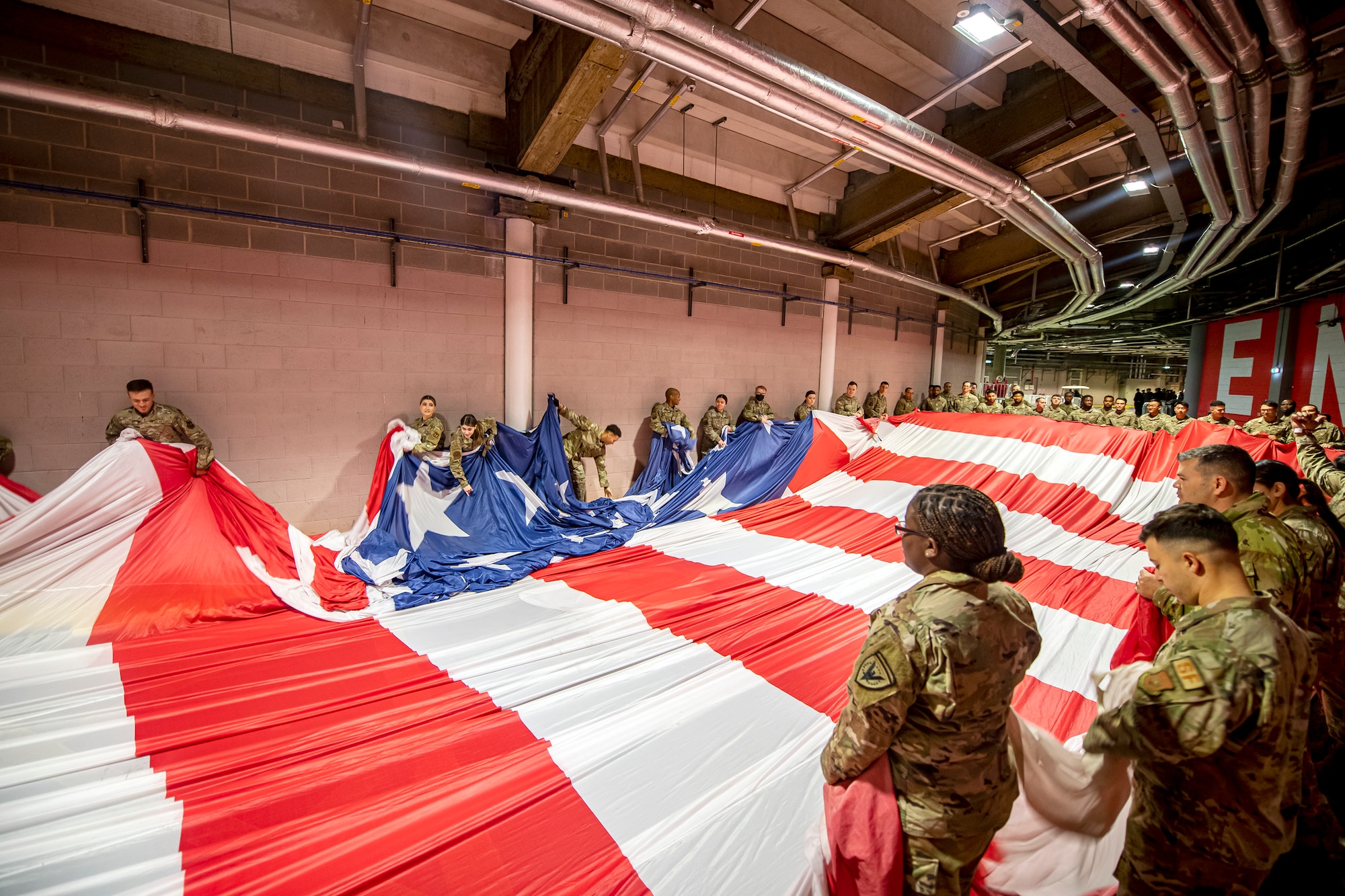 Airmen from the 501st Combat Support Wing, fold an American flag prior to a national anthem demonstration at Wembley Stadium, in London, England, Oct. 30, 2022. Approximately 70 uniformed personnel represented the U.S. Air Force and nation by unveiling an American flag during the pre-game ceremonies of the Jacksonville Jaguars and Denver Broncos NFL game. (U.S. Air Force photo by Staff Sgt. Eugene Oliver)