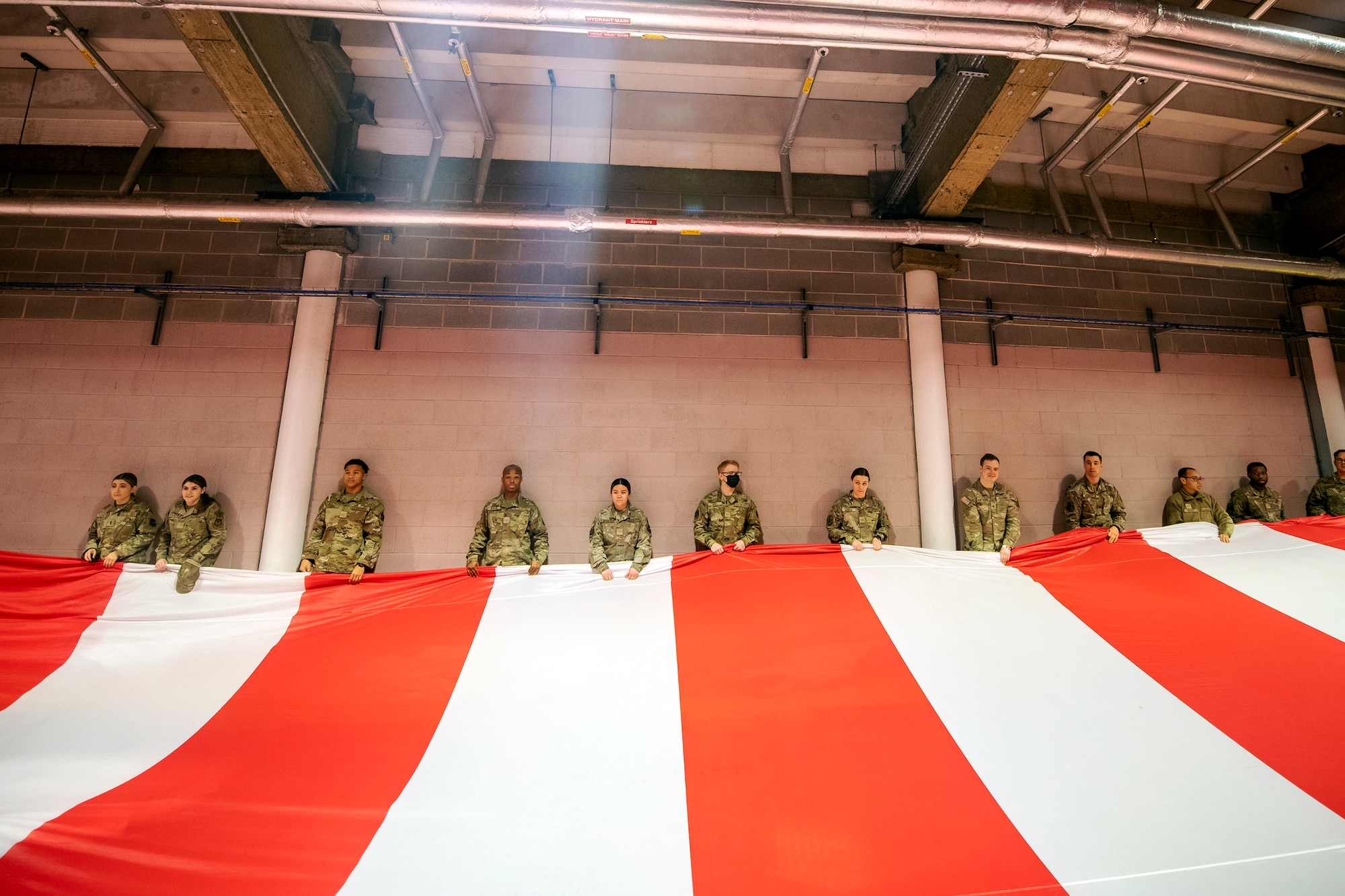 Airmen from the 501st Combat Support Wing hold an American flag prior to a national anthem demonstration at Wembley Stadium, in London, England, Oct. 30, 2022. Approximately 70 uniformed personnel represented the U.S. Air Force and nation by unveiling an American flag during the pre-game ceremonies of the Jacksonville Jaguars and Denver Broncos NFL game.  (U.S. Air Force photo by Staff Sgt. Eugene Oliver)