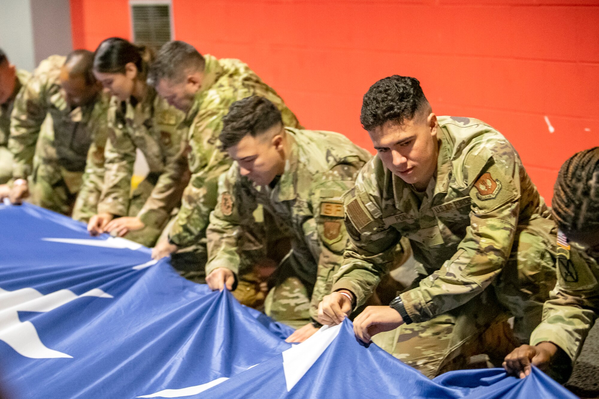 Airmen from the 501st Combat Support Wing fold an American flag at Wembley Stadium, in London, England, Oct. 30, 2022. Approximately 70 uniformed personnel represented the U.S. Air Force and nation by unveiling an American flag during the pre-game ceremonies of the Jacksonville Jaguars and Denver Broncos NFL game. (U.S. Air Force photo by Staff Sgt. Eugene Oliver)