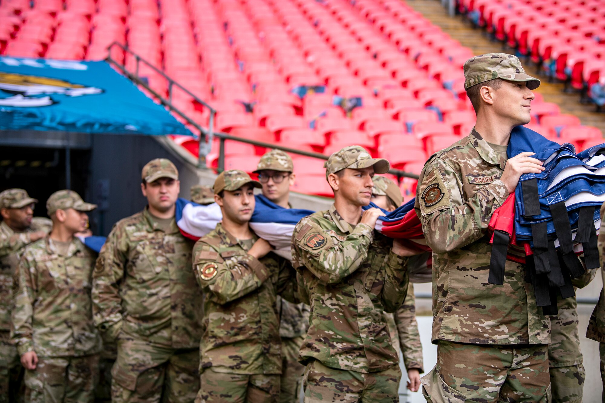 Airmen from the 501st Combat Support Wing hold an American flag prior to national anthem rehearsal at Wembley Stadium, in London, England, Oct. 30, 2022. Approximately 70 uniformed personnel represented the U.S. Air Force and nation by unveiling an American flag during the pre-game ceremonies of the Jacksonville Jaguars and Denver Broncos NFL game. (U.S. Air Force photo by Staff Sgt. Eugene Oliver)