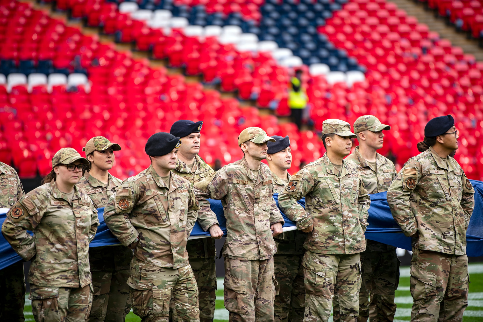 Airmen from the 501st Combat Support Wing hold an American flag during national anthem rehearsal at Wembley Stadium, in London, England, Oct. 30, 2022. Approximately 70 uniformed personnel represented the U.S. Air Force and nation by unveiling an American flag during the pre-game ceremonies of the Jacksonville Jaguars and Denver Broncos NFL game. (U.S. Air Force photo by Staff Sgt. Eugene Oliver)