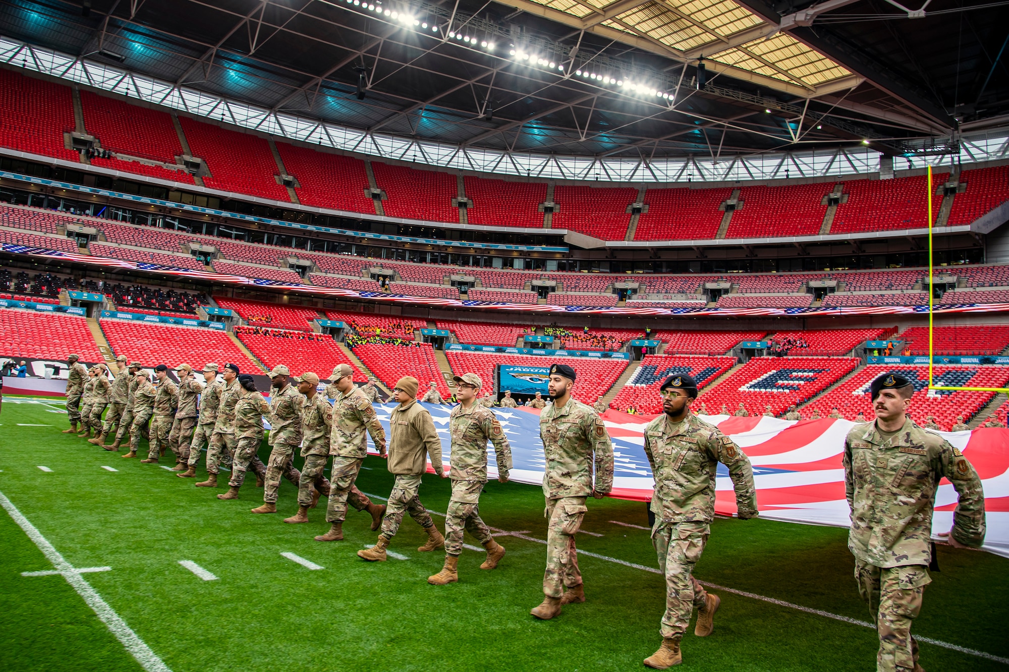 Airmen from the 501st Combat Support Wing rehearse unveiling an American flag at Wembley Stadium, in London, England, Oct. 30, 2022. Approximately 70 uniformed personnel represented the U.S. Air Force and nation by unveiling an American flag during the pre-game ceremonies of the Jacksonville Jaguars and Denver Broncos NFL game. (U.S. Air Force photo by Staff Sgt. Eugene Oliver)