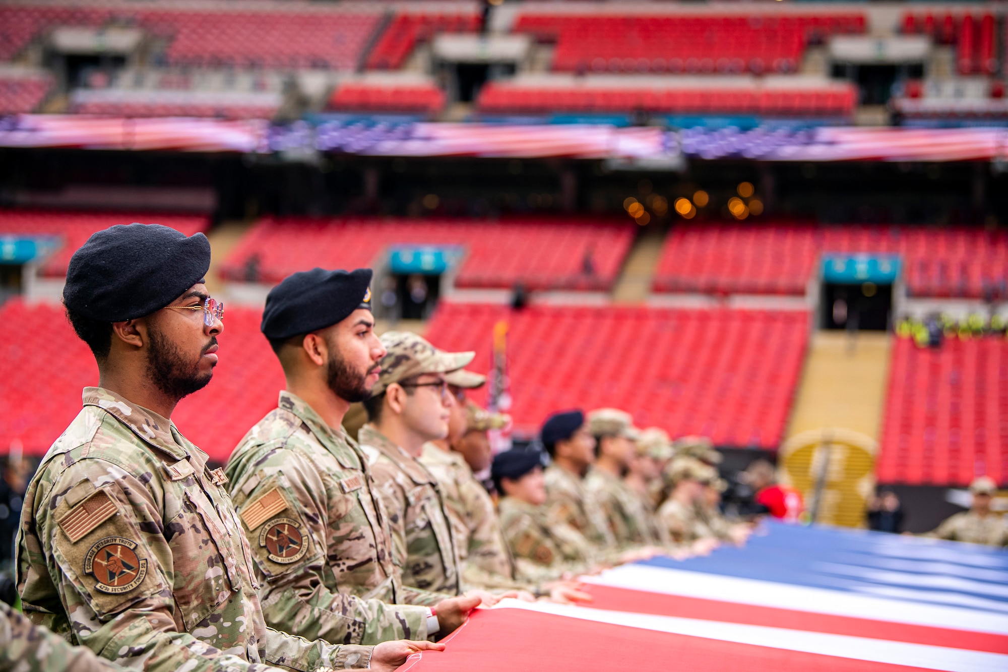 Airmen from the 501st Combat Support Wing rehearse unveiling an American flag at Wembley Stadium, in London, England, Oct. 30, 2022. Approximately 70 uniformed personnel represented the U.S. Air Force and nation by unveiling an American flag during the pre-game ceremonies of the Jacksonville Jaguars and Denver Broncos NFL game. (U.S. Air Force photo by Staff Sgt. Eugene Oliver)