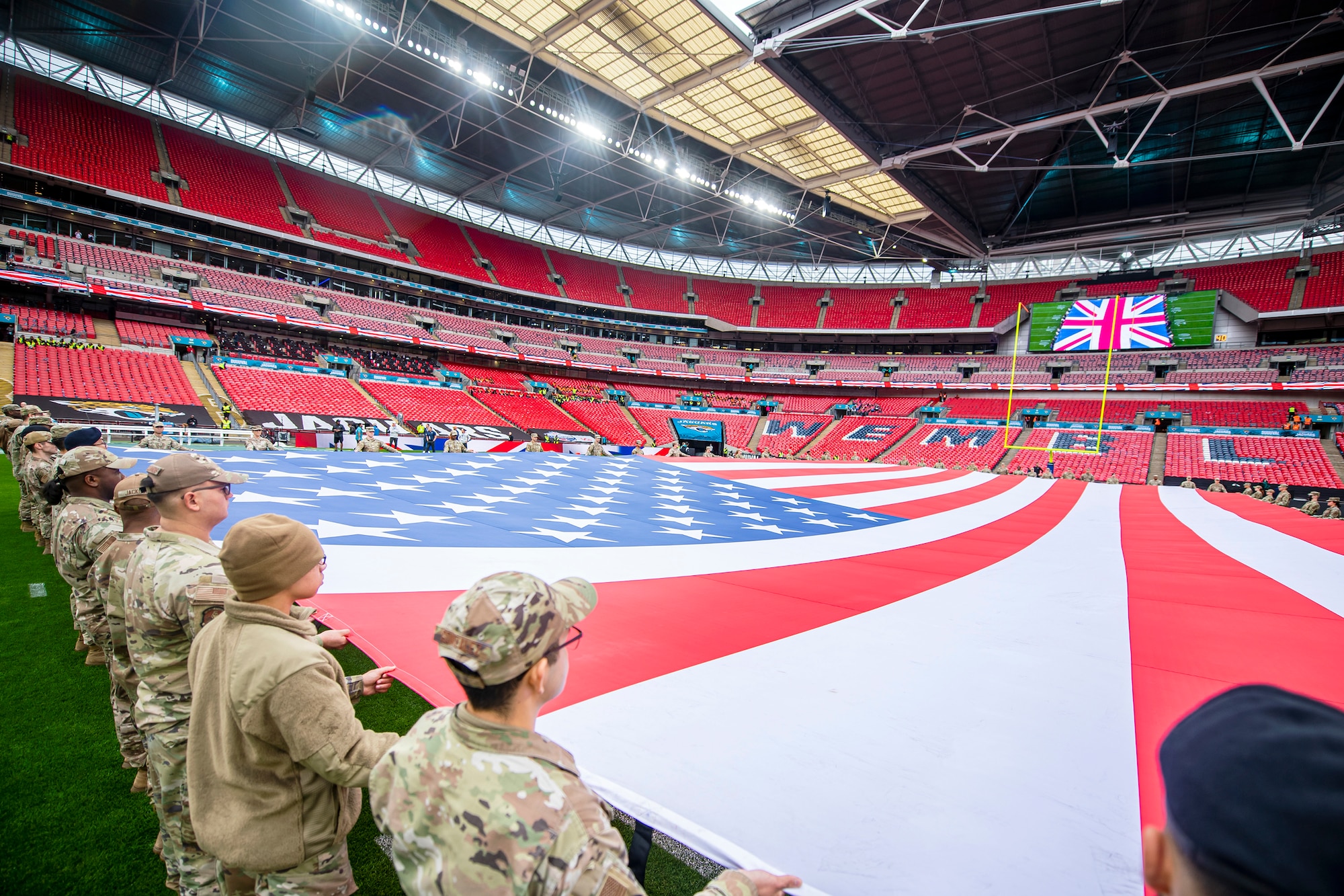 Airmen from the 501st Combat Support Wing rehearse unveiling an American flag at Wembley Stadium, in London, England, Oct. 30, 2022. Approximately 70 uniformed personnel represented the U.S. Air Force and nation by unveiling an American flag during the pre-game ceremonies of the Jacksonville Jaguars and Denver Broncos NFL game. (U.S. Air Force photo by Staff Sgt. Eugene Oliver)