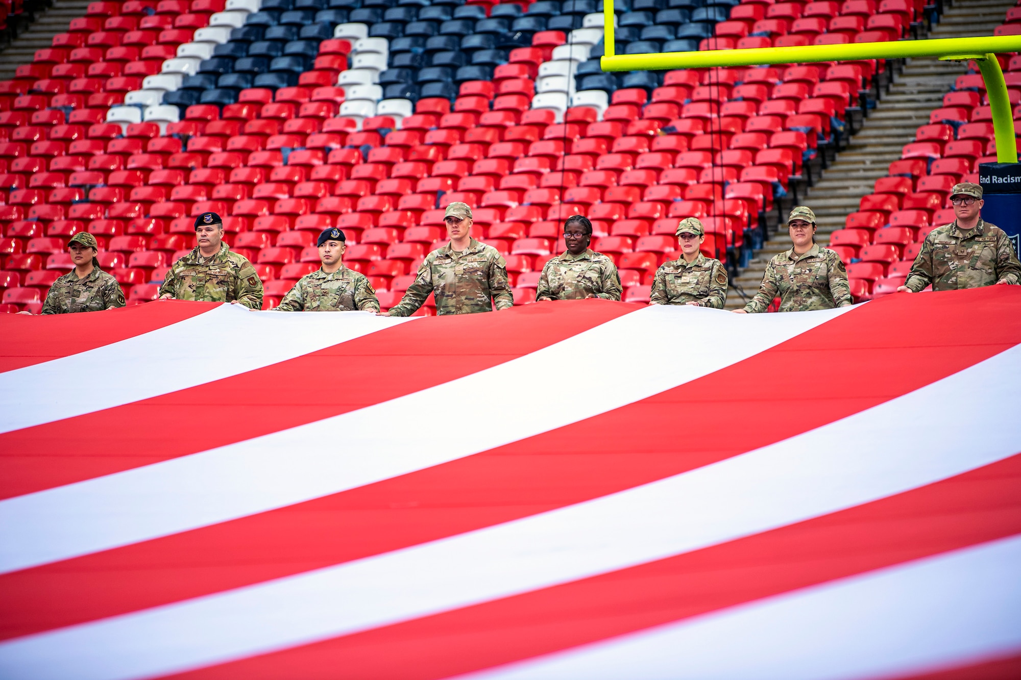 Airmen from the 501st Combat Support Wing rehearse unveiling an American flag at Wembley Stadium, in London, England, Oct. 30, 2022. Approximately 70 uniformed personnel represented the U.S. Air Force and nation by unveiling an American flag during the pre-game ceremonies of the Jacksonville Jaguars and. Denver Broncos NFL game. (U.S. Air Force photo by Staff Sgt. Eugene Oliver)