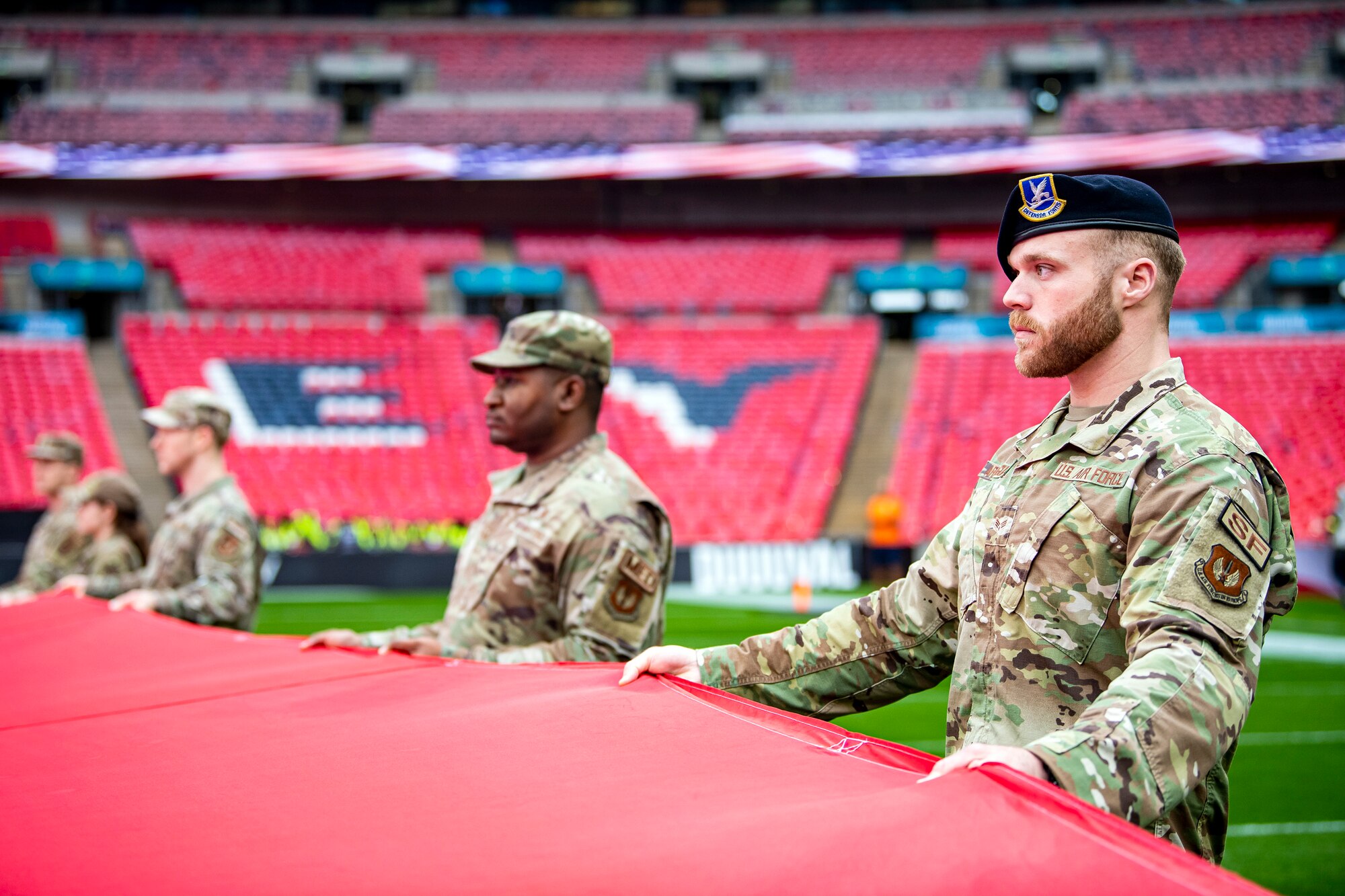 Airmen from the 501st Combat Support Wing rehearse unveiling an American flag at Wembley Stadium, in London, England, Oct. 30, 2022. Approximately 70 uniformed personnel represented the U.S. Air Force and nation by unveiling an American flag during the pre-game ceremonies of the Jacksonville Jaguars and Denver Broncos NFL game. (U.S. Air Force photo by Staff Sgt. Eugene Oliver)