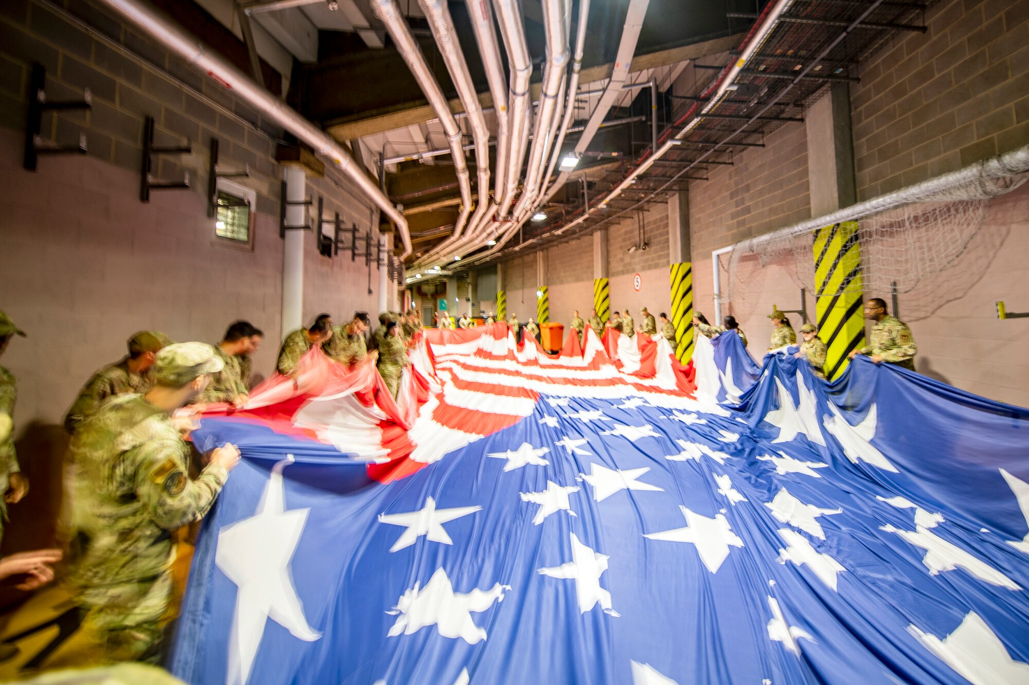 Airmen from the 501st Combat Support Wing fold an American flag prior to the national anthem at Wembley Stadium, in London, England, Oct. 30, 2022. Approximately 70 uniformed personnel represented the U.S. Air Force and nation by unveiling an American flag during the pre-game ceremonies of the Jacksonville Jaguars and Denver Broncos NFL game. (U.S. Air Force photo by Staff Sgt. Eugene Oliver)