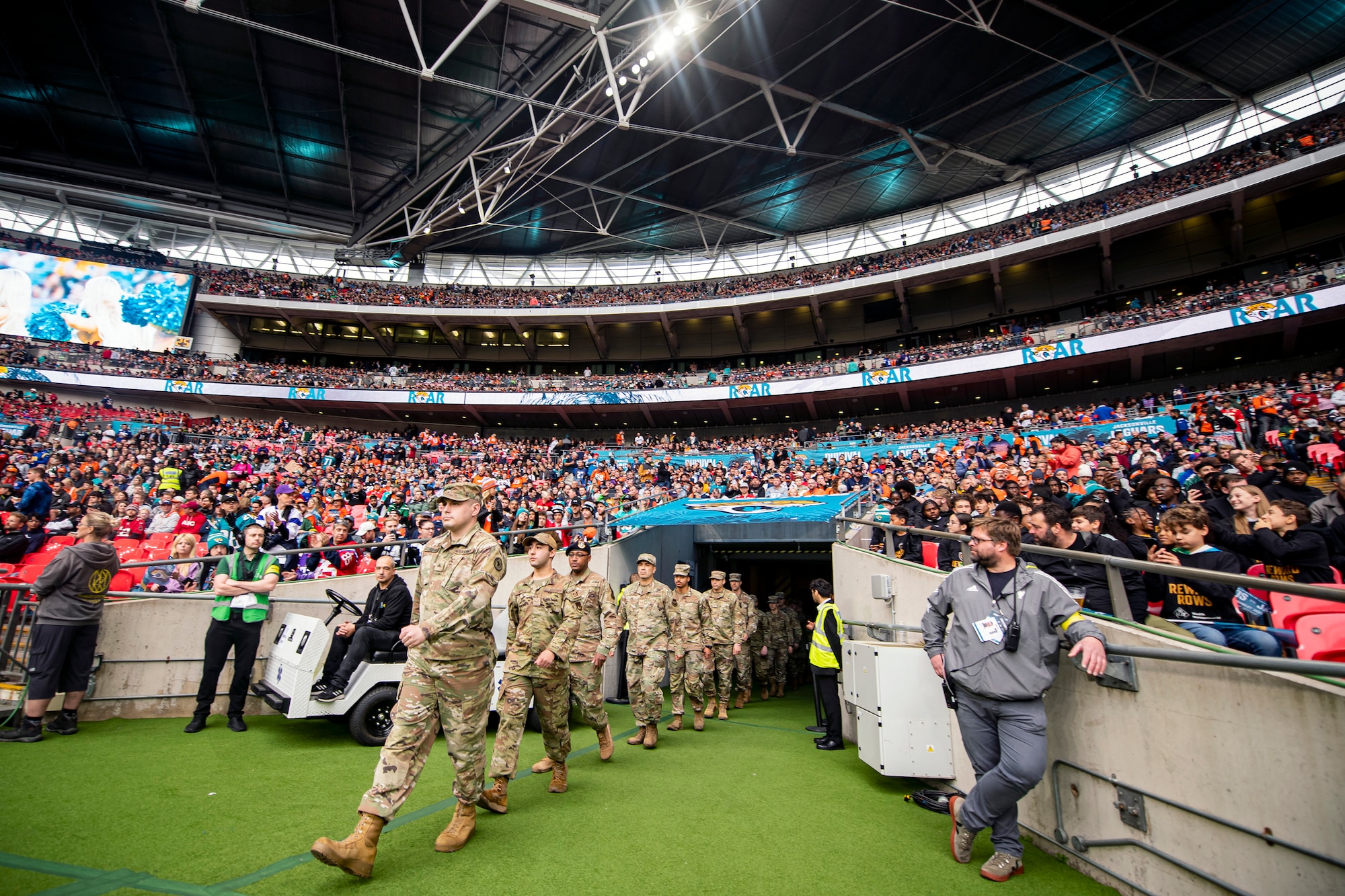 Airmen from the 501st Combat Support Wing walk on the field prior to the national anthem at Wembley Stadium, in London, England, Oct. 30, 2022. Approximately 70 uniformed personnel represented the U.S. Air Force and nation by unveiling an American flag during the pre-game ceremonies of the Jacksonville Jaguars and Denver Broncos NFL game. (U.S. Air Force photo by Staff Sgt. Eugene Oliver)