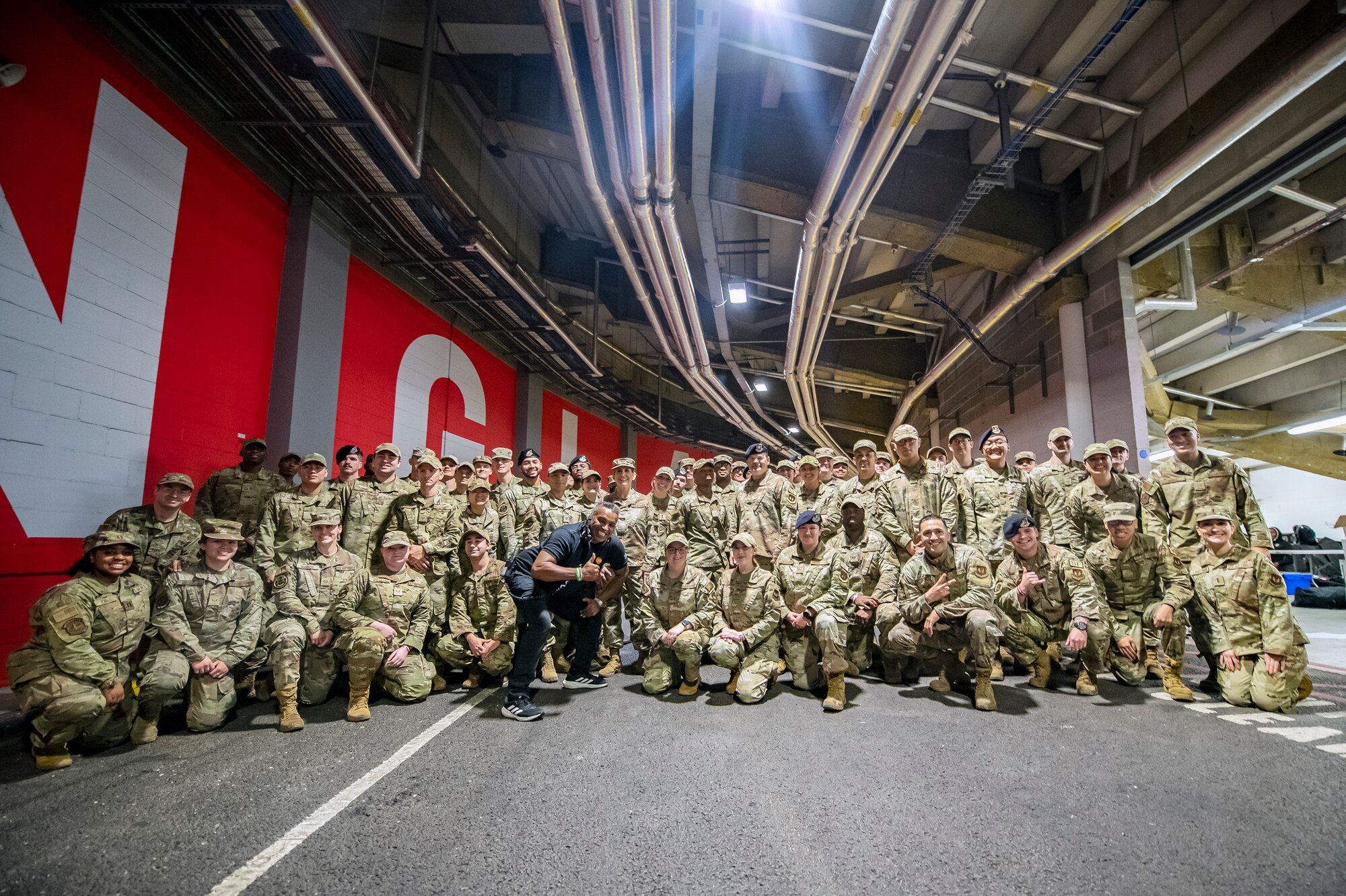 Airmen from the 501st Combat Support Wing pose for a group photo following the national anthem at Wembley Stadium, in London, England, Oct. 30, 2022. Approximately 70 uniformed personnel represented the U.S. Air Force and nation by unveiling an American flag during the pre-game ceremonies of the Jacksonville Jaguars and Denver Broncos NFL game. (U.S. Air Force photo by Staff Sgt. Eugene Oliver)