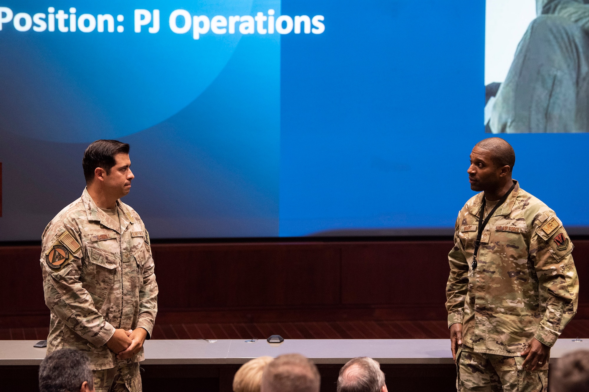 Chief Master Sgt. Jerome Wright (right), Command Chief for the Air Force Technical Applications Center at Patrick Space Force Base, Fla., shows his admiration for Air Force Pararescueman Tech. Sgt. August O’Niell after O’Niell briefed the nuclear treaty monitoring center Oct. 20, 2022 about the circumstances he faced in combat that led to the amputation of his left leg, and how he fought to remain on active duty.  (U.S. Air Force photo by Matthew S. Jurgens)