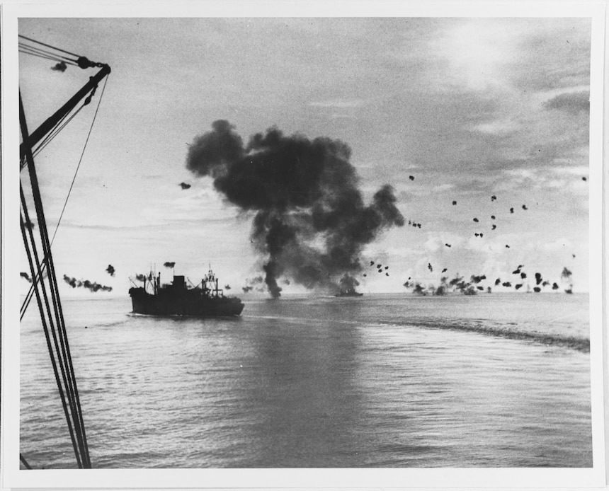 Photographed from USS President Adams (AP-38), USS President Jackson (AP-37) maneuvers under Japanese air attack off Guadalcanal, 12 November 1942. In the center background is smoke from an enemy plane that had just crashed into the after superstructure of USS San Francisco (CA-38), which is steaming away in the right center. Official U.S. Navy Photograph, now in the collections of the National Archives. (80-G-32366)