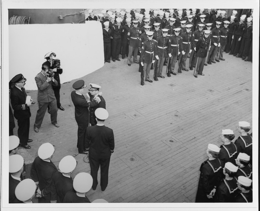 Commander Bruce McCandless receives the Medal of Honor from Admiral Ernest J. King (Chief of Naval Operations and Commander in Chief, U.S. Fleet), in ceremonies on board USS San Francisco (CA-38), 12 December 1942. McCandless was awarded the medal for conspicuous gallantry and exceptionally distinguished service during the Naval Battle of Guadalcanal, 12-13 November 1942. Part of the ship beyond the photographers has been obscured by wartime censors. Official U.S. Navy Photography, now in the collections of the National Archives. (80-G-31580)