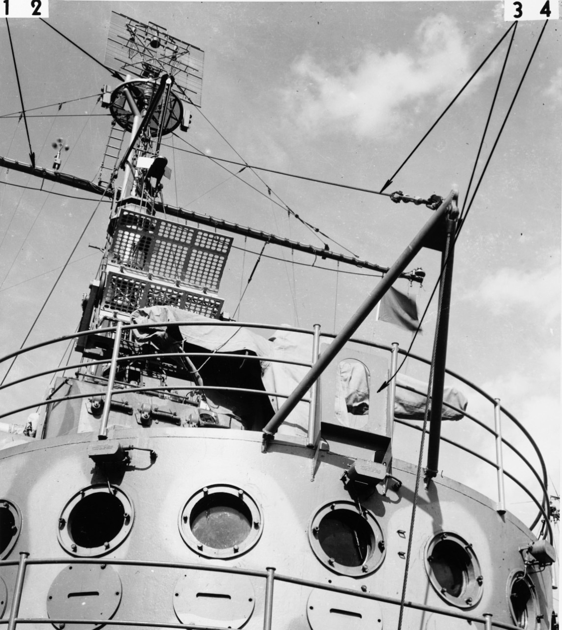 USS Juneau (CL-52) at the New York Navy Yard, 19 March 1942. View of bridge area, with arrows marking recent changes. Note “SC” search radar and MK-4 (“FD”) fire control radar. (19-N-31273)