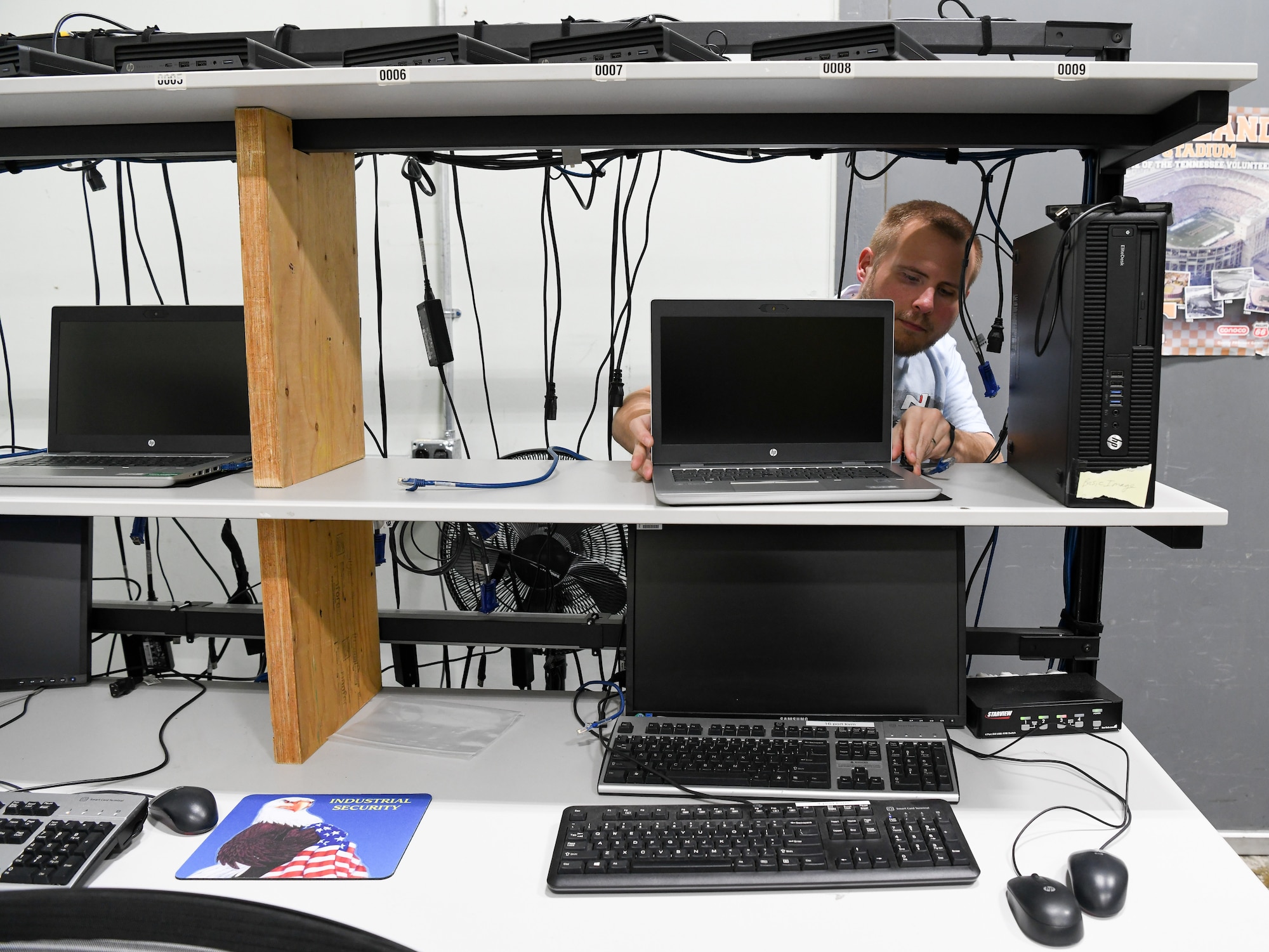 Jonathan Poe, a computer network technician IV, sits and works in the computer staging area.