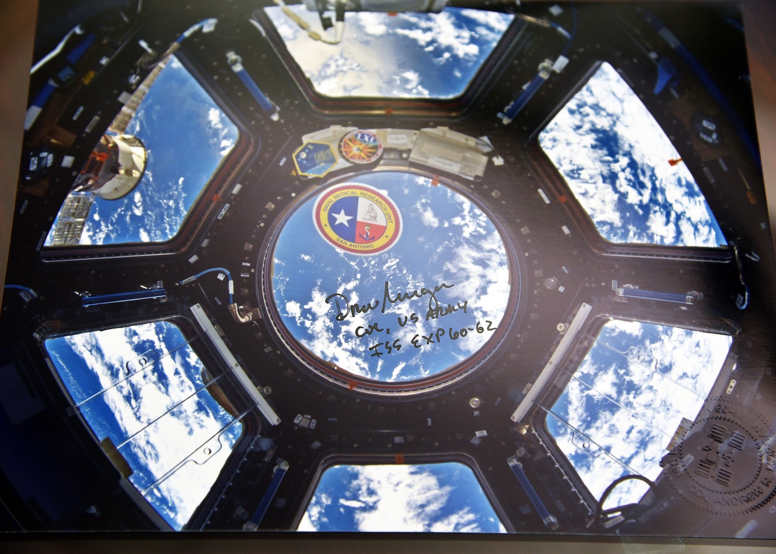 A command coin and logo sticker from Naval Medical Research Unit San Antonio taken aboard the International Space Station
