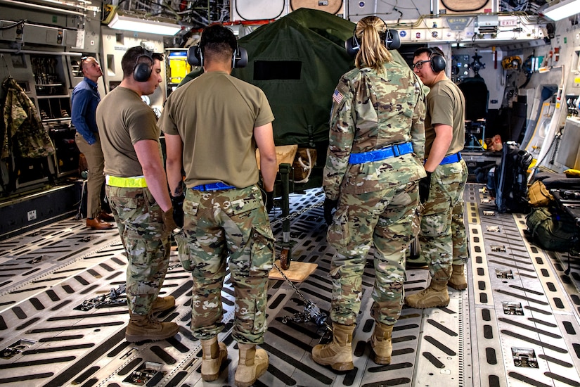 Troops load a device on an aircraft.