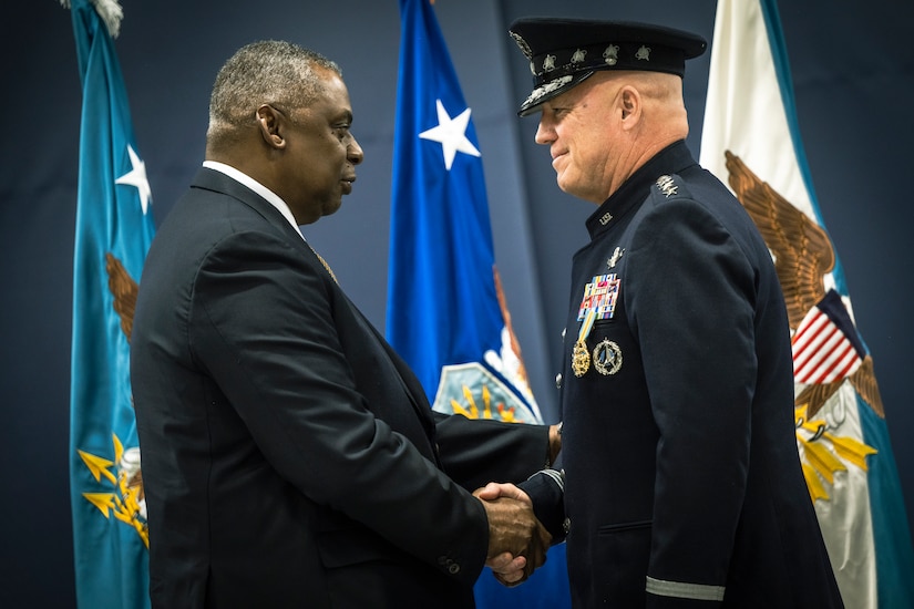 Two men shake hands.