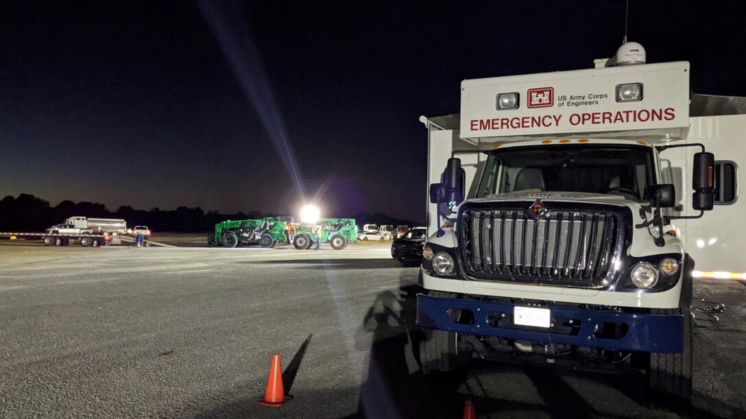 A deployable tactical operations system (DTOS) stands by as planning and response team (PRT) members prepare generators for use at a generator staging base in Alabama before Hurricane Ian’s landfall. A DTOS is a mobile command and control centers that include workstations, internet, and other communications capabilities for personnel to use anywhere during disaster response and recovery operations. The DTOS pictured is at a generator staging base situated at the edge of a natural disaster’s impact zone where PRTs prepare temporary emergency generators for quick use. (U.S. Army courtesy photo by Pittsburgh District)