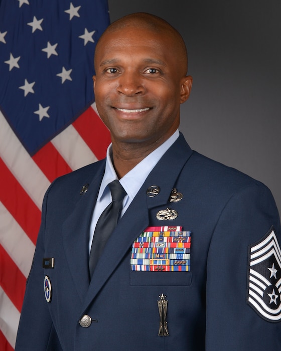 Air Force official photo of an Airman in a blue military suit.