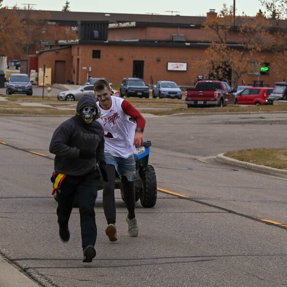 A competitor in the Zombie 5K Run is chased down by a zombie Oct. 31, 2022 at Minot Air Force Base N.D. During the run, participants wore flags on their waists and the zombies attempted to take flags. (U.S. Air Force photo by Senior Airman Evan Lichtenhan)