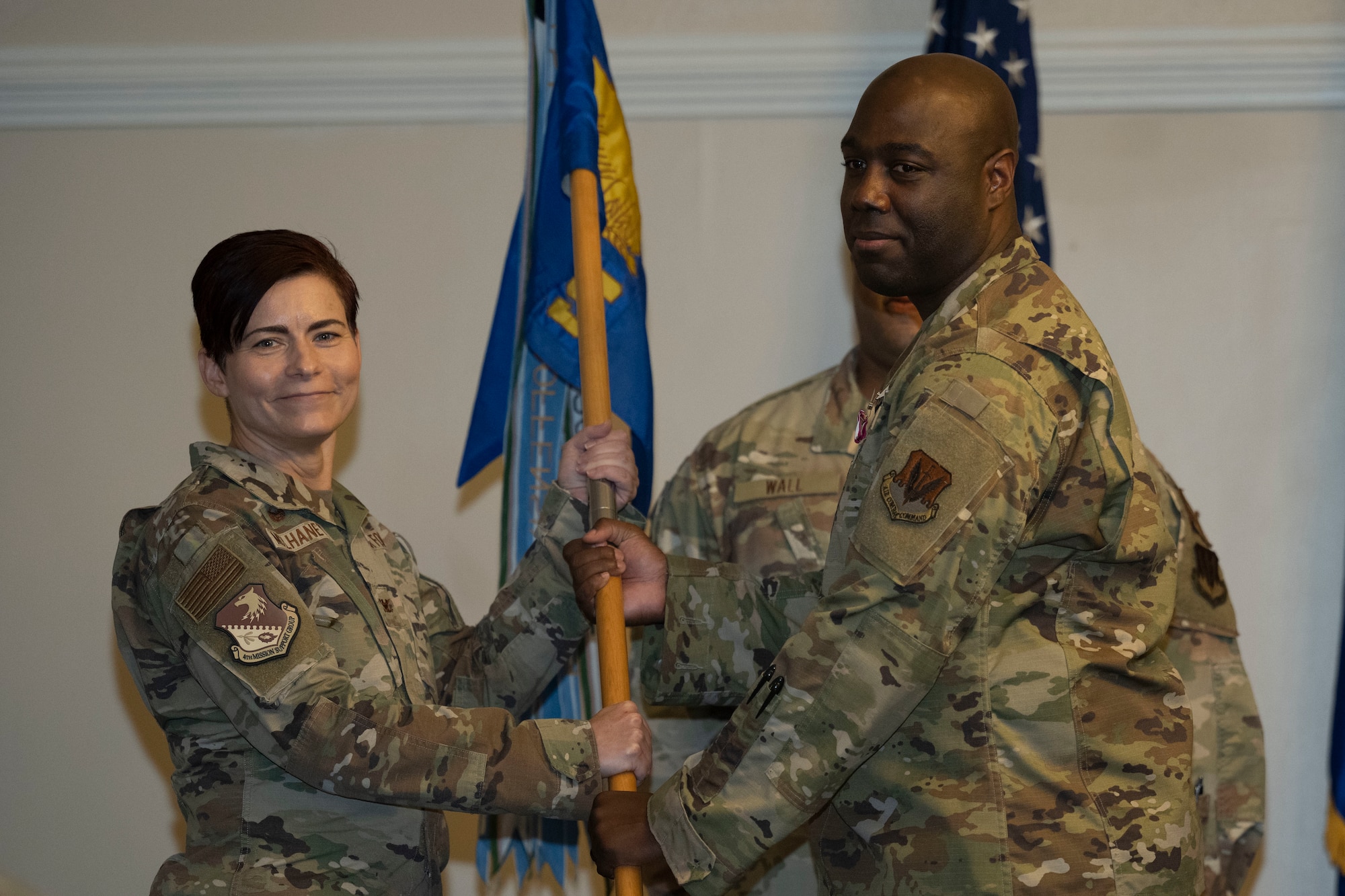Maj. Terrence Briggs, outgoing 4th Communications Squadron commander, passes the 4th CS guidon to Col. Tammy McElhaney, 4th Mission Support Group commander, after relinquishing command during a  change of command ceremony at Seymour Johnson Air Force Base, North Carolina, Oct. 28, 2022. The ceremony is a military tradition that represents a formal transfer of a unit’s authority and responsibility from one commander to another. (U.S. Air Force photo by Senior Airman Kevin Holloway)