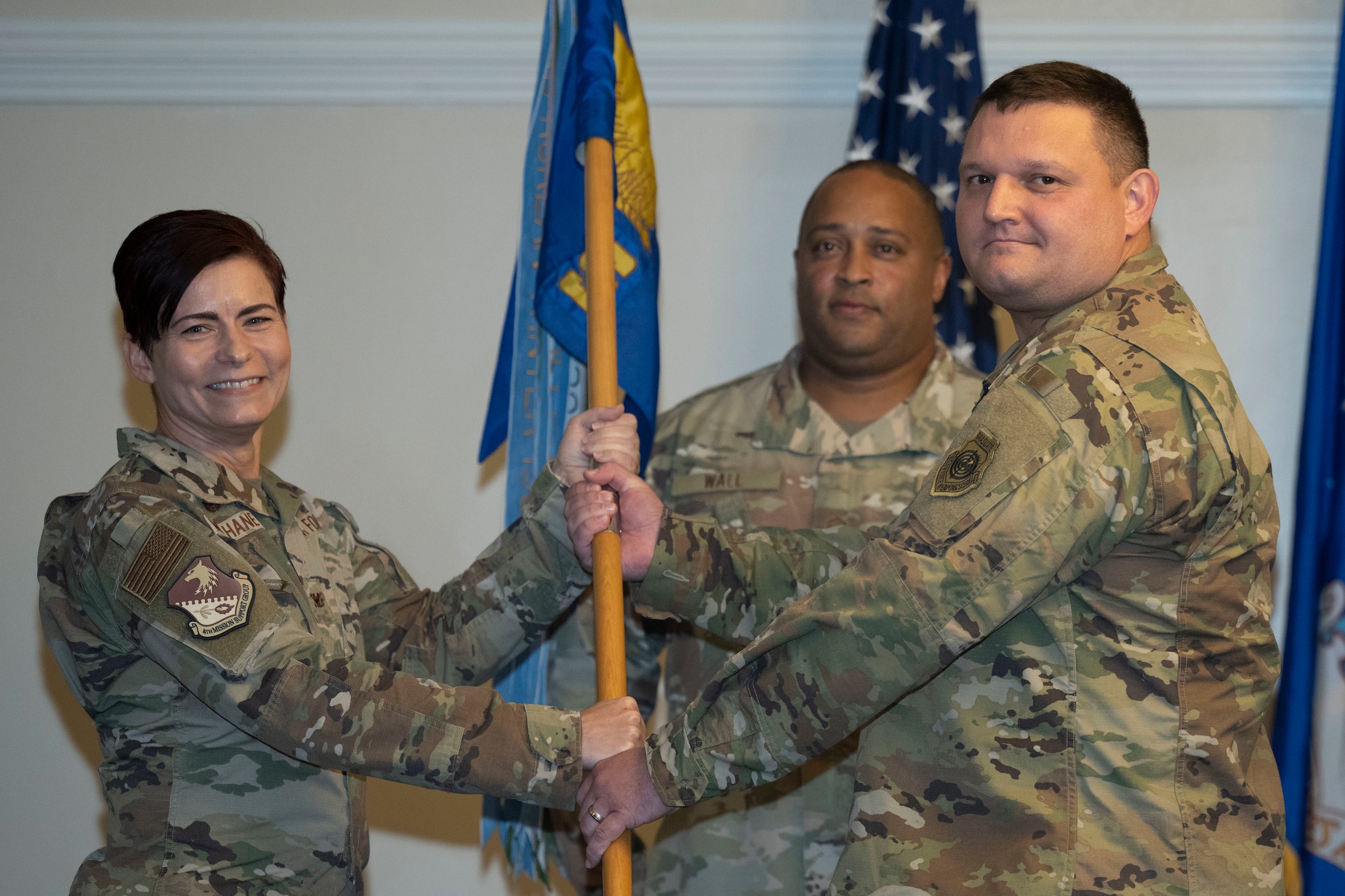 Col. Tammy McElhaney, 4th Mission Support Group commander, passes the 4th Communications Squadron guidon to Maj. Joshua Gminski, incoming 4th CS commander, during a change of command ceremony at Seymour Johnson Air Force Base, North Carolina, Oct. 28, 2022. The passing of a unit's guidon symbolizes a transfer of command. (U.S. Air Force photo by Senior Airman Kevin Holloway)