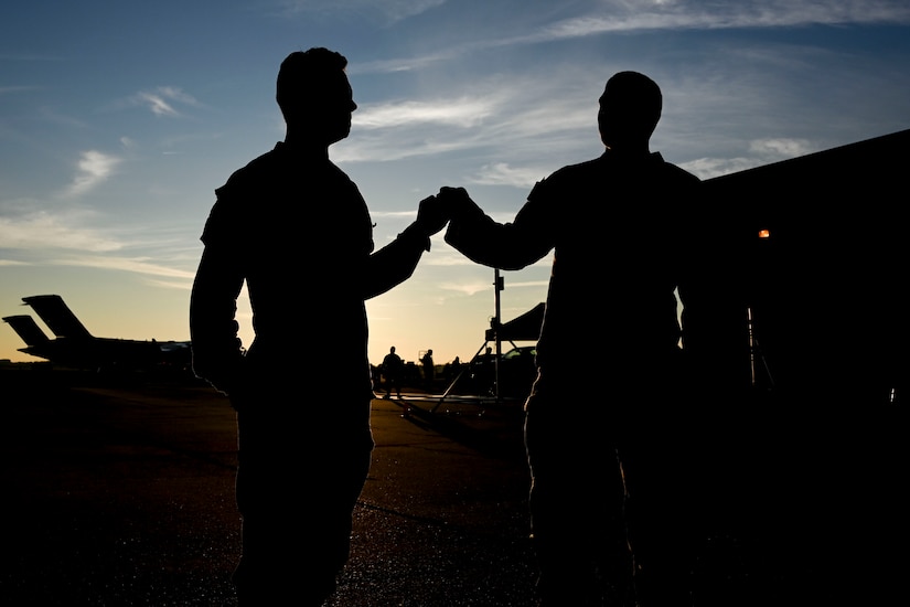 Pfc. Cayman Pope (left), and Pfc. Dalton Cooley (right), 2-263rd Air Defense Artillery Battalion air defense battle systems operators, bump fists prior to a training exercise at Joint Base Andrews, Md., Nov. 2, 2022. For the training, the 2-263rd brought vehicles and equipment to practice processing through JBA’s cargo deployment function point of debarkation. (U.S. Air Force photo by Staff Sgt. Spencer Slocum)