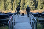 Tulalip Tribes Natural Resources wildlife biologists Annalei Lees, left, and Glenn Meador, carry a trapped North American beaver to a vehicle at Naval Radio Station Jim Creek, Washington, Oct. 12.