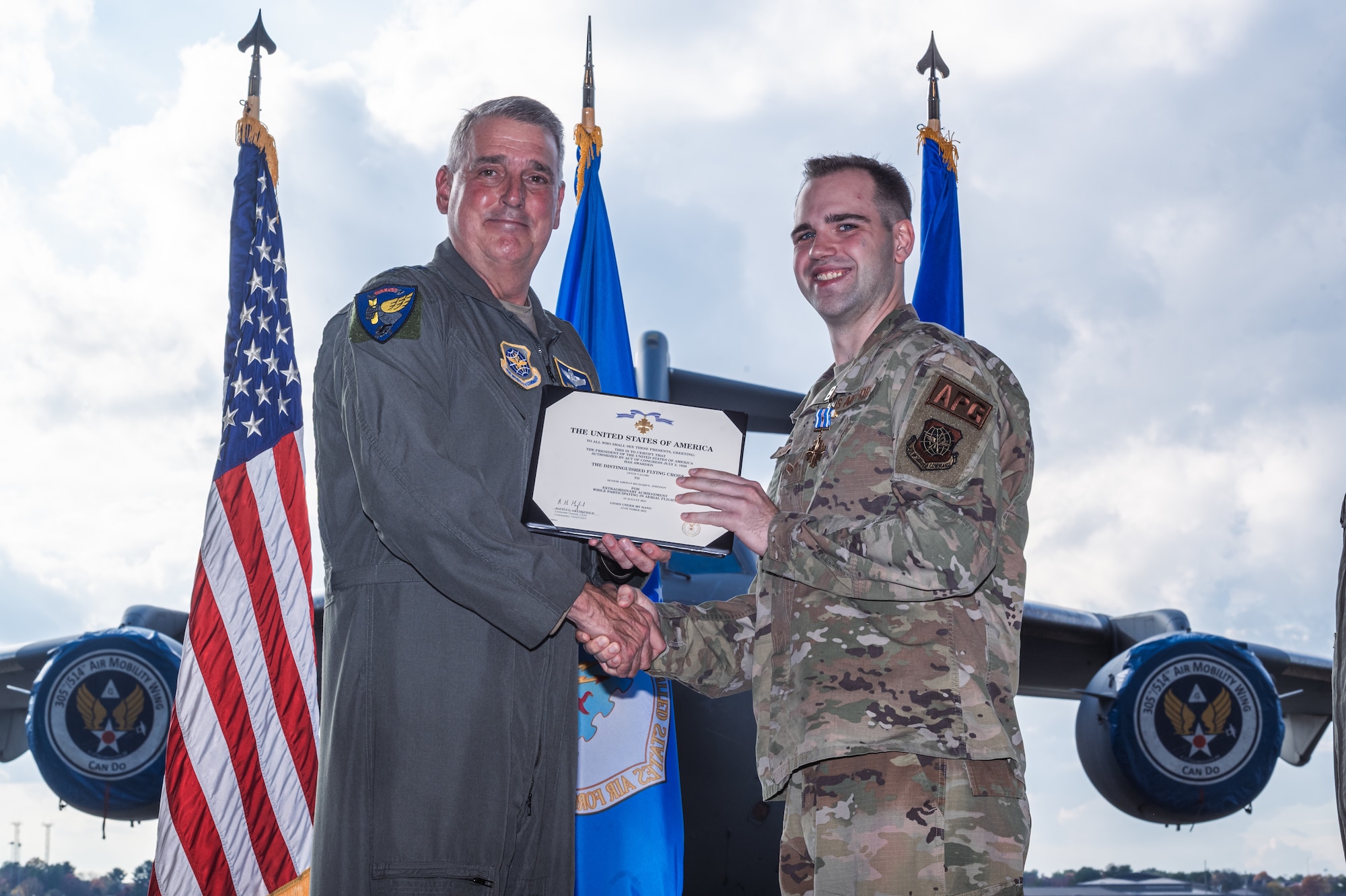 U.S. Air Force Senior Airman Richard Johnson, 305th Aircraft Maintenance Squadron flying crew chief, is awarded the distinguished flying cross with valor by Gen. Mike Minihan, Air Mobility Command commander, on Joint Base McGuire-Dix-Lakehurst, N.J., Nov. 1, 2022. The distinguished flying cross with valor is one of the highest awards for extraordinary achievement and is awarded for heroism while participating in aerial flight. (U.S. Air Force photo by Senior Airman Joseph Morales)