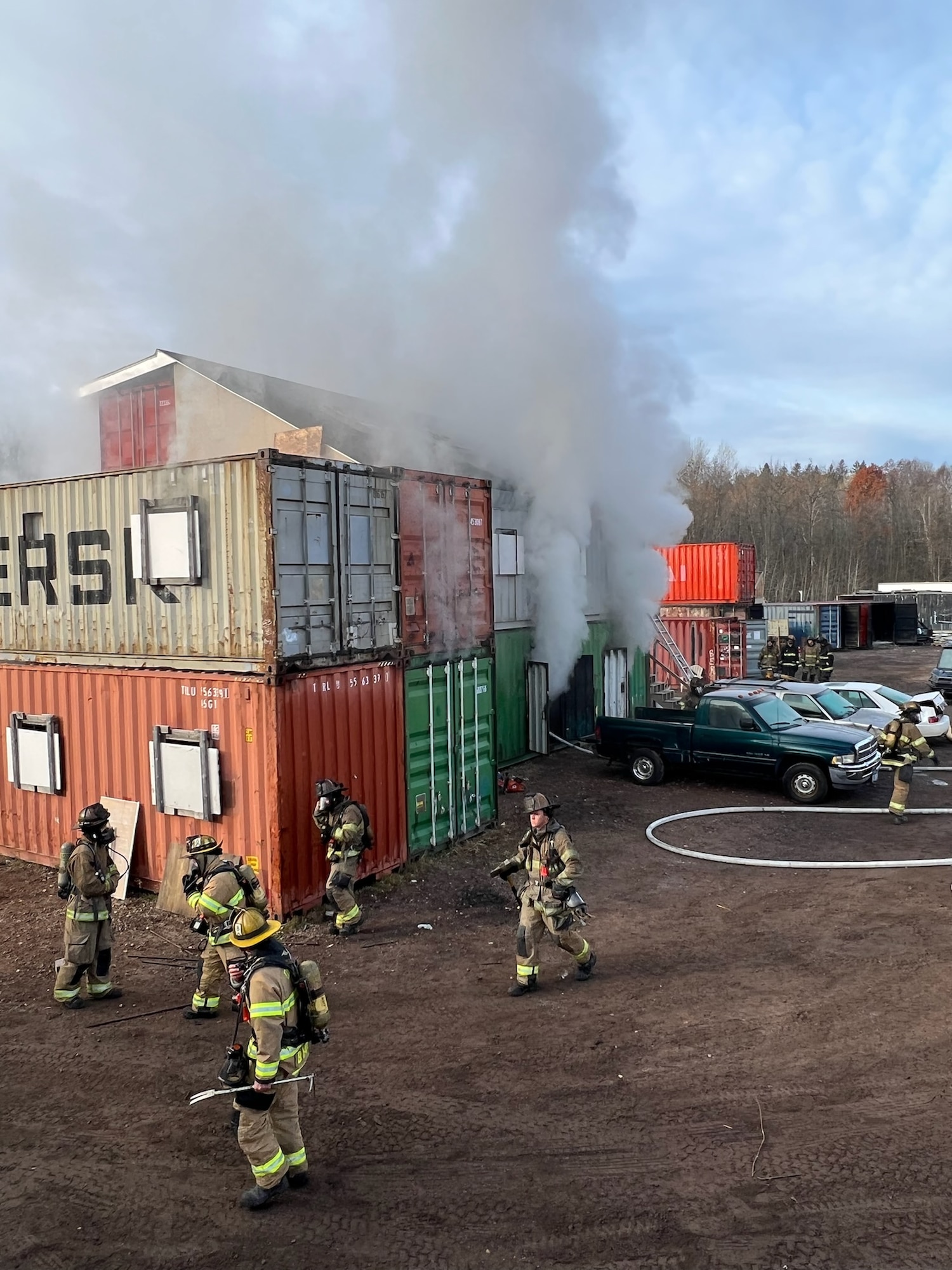 Newly hired fire fighters assigned to the 148th Fighter Wing, Minnesota Air National Guard Fire Department, Duluth Fire Department, and Superior Fire Department respond to a structure fire during a training live fire evolution at Lake Superior College's Emergency Response Training Center, Duluth, Minnesota, October 27, 2022.