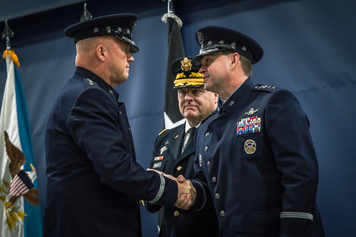 Two men shake hands.