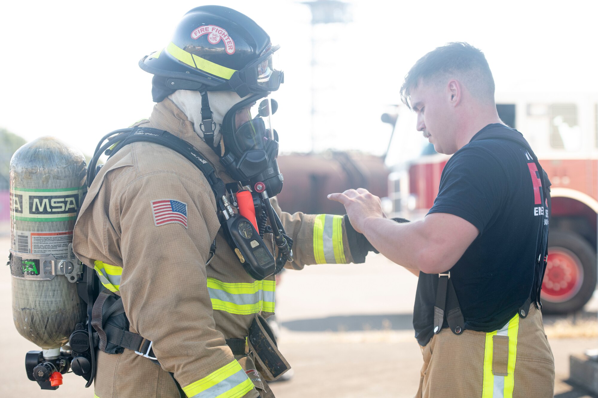 Staff Sgt. Christopher Gold, 374th Civil Engineer Squadron firefighter crew chief, inspects another firefighter's gear during a bilateral training with the Japan Air Self-Defense Force at Yokota Air Base, Japan, Oct. 28, 2022.