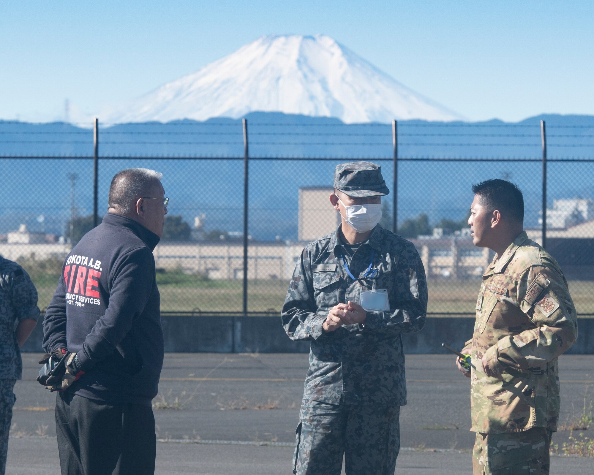 Master Sgt. Jayson Marquez, 374th Civil Engineer Squadron assistant chief for fire prevention, right, talks with Col. Atsushi Yamakawa, Central Aircraft Control and Warning Wing vice commander, center, during a bilateral training at Yokota Air Base, Japan, Oct. 26, 2022.