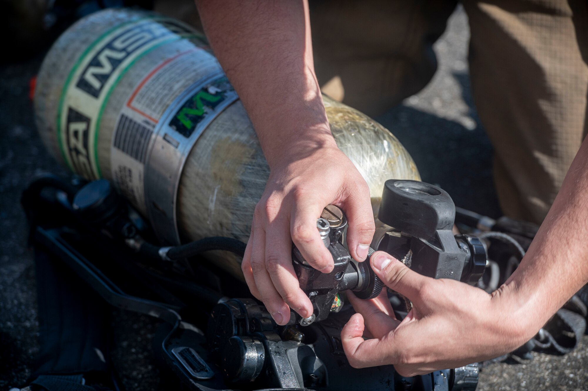 A firefighter with the 374th Civil Engineer Squadron inspects a self-contained breathing apparatus during a bilateral training with the Japan Air Self-Defense Force at Yokota Air Base, Japan, Oct. 28, 2022.