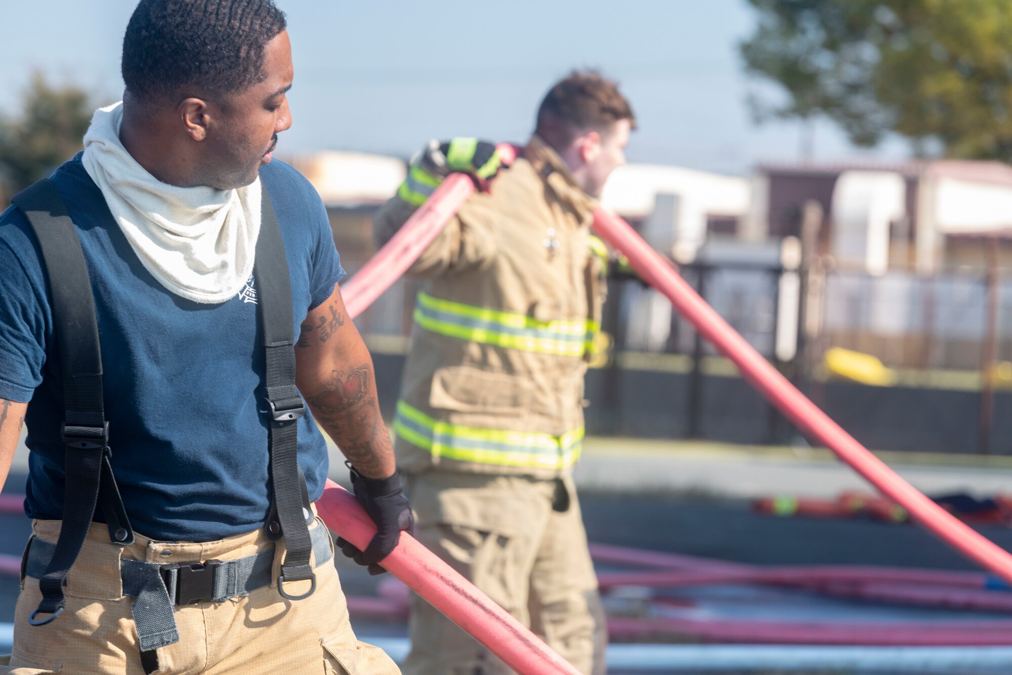 Airman 1st Class Corey White, 374th Civil Engineer Squadron fire truck operator, pulls a hose away from a building after successfully putting out a simulated building fire during a bilateral training with the Japan Air Self-Defense Force at Yokota Air Base, Japan, Oct. 28, 2022.