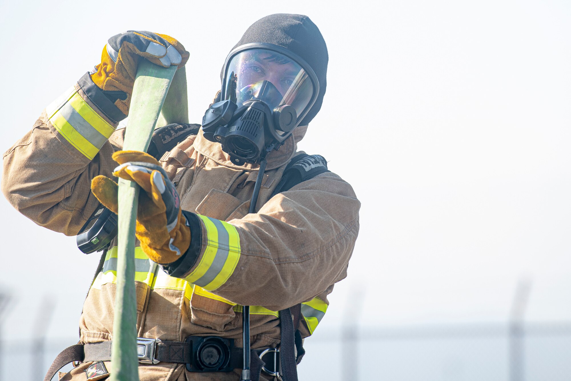 Staff Sgt. Christopher Gold, 374th Civil Engineer Squadron firefighter crew chief, wrings out a fire hose before storing it on a fire truck during a bilateral training with the Japan Air Self Defense Force at Yokota Air Base, Japan, Oct. 28, 2022.