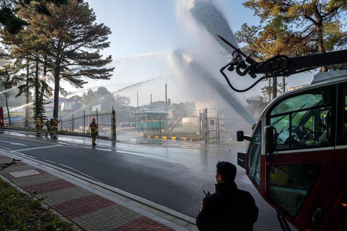 Republic of Korea Air Force firefighters and the 51st Civil Engineer Squadron Fire Department spray water on a simulated fire during a joint training exercise at Osan Air Base, ROK, Oct. 27, 2022.