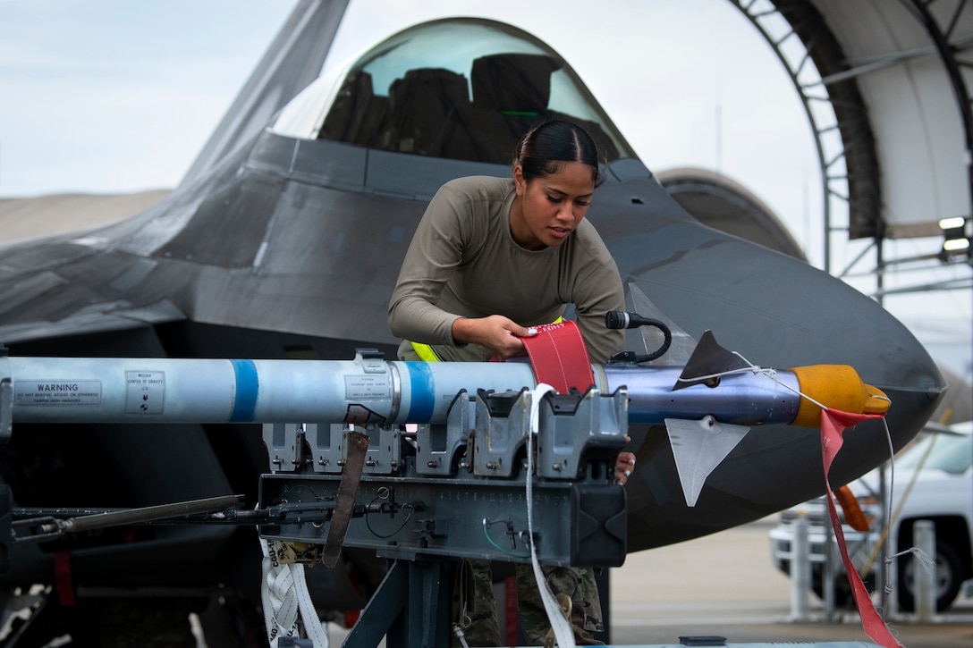 An airman  examines a missile.