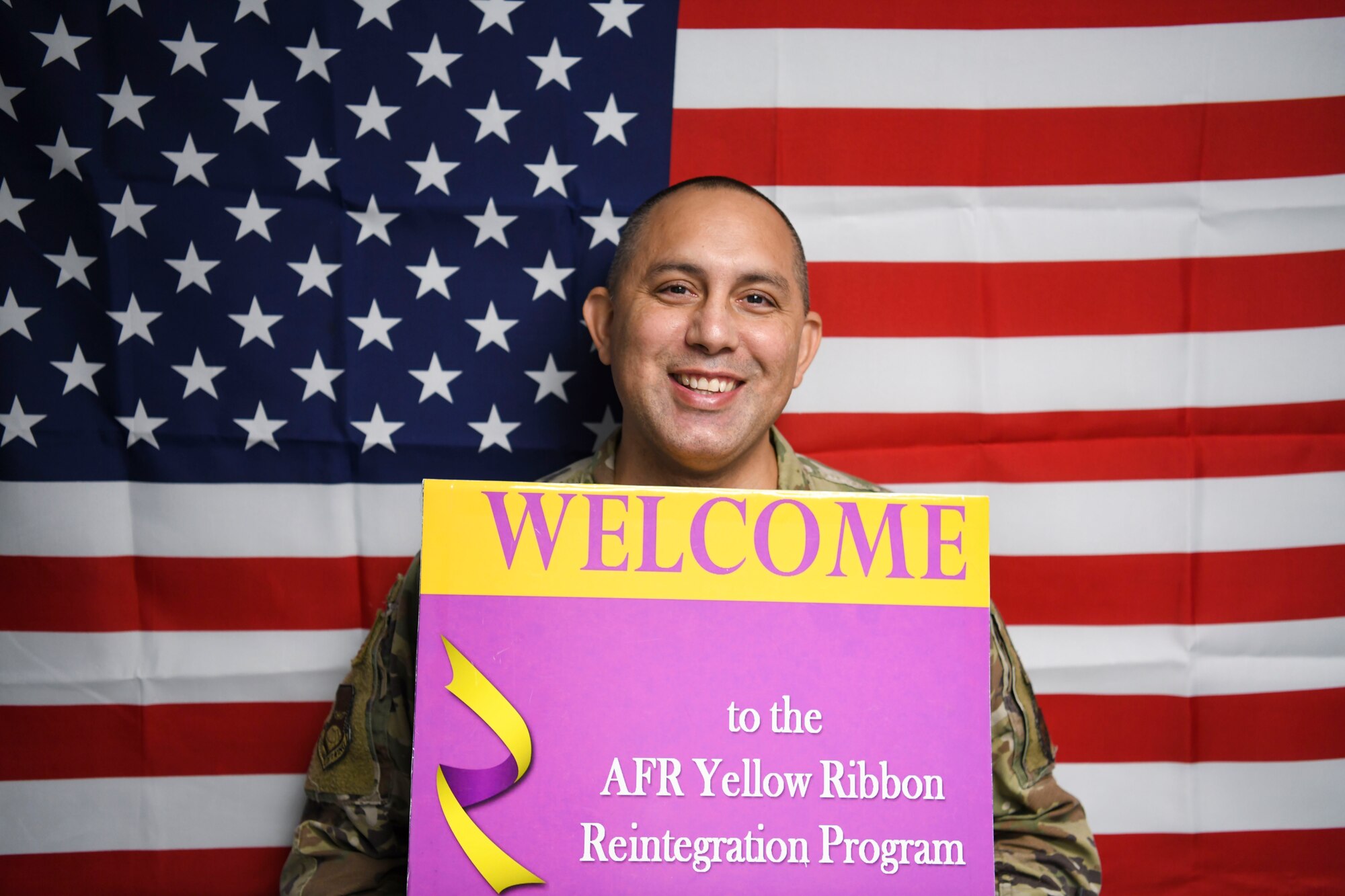 Master Sgt. William Bonner, 433rd Airlift Wing and 960th Cyberspace Wing Yellow Ribbon Program representative, holds a welcome sign for all current and future deployers to contact him about the Air Force Reserve Program Oct. 20, 2022, at Joint Base San Antonio-Lackland, Texas. (U.S. Air Force photo by Samantha Mathison)