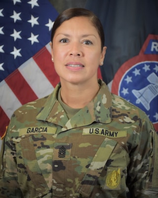 Female Soldier in uniform in front of U.S. and Army Recruiting flags