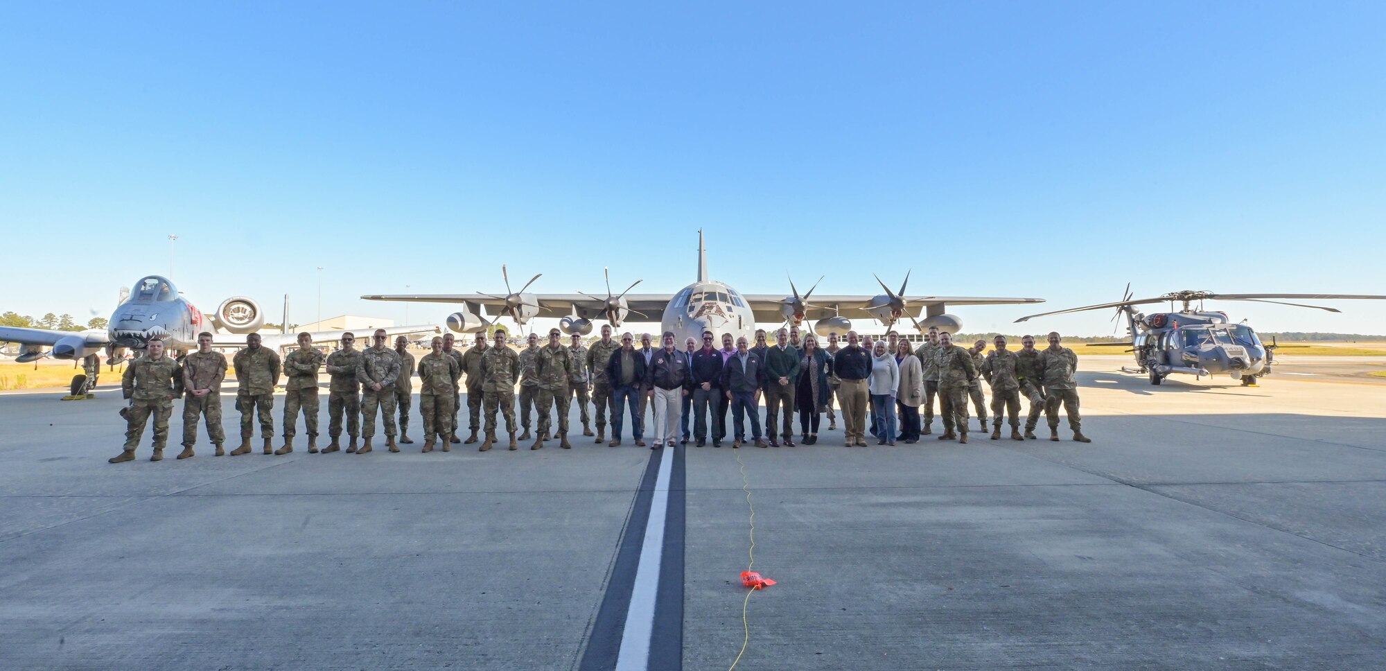 U.S. Air Force Airmen with the 23rd Maintenance Group join honorary commanders for a photo in front of an A-10C Thunderbolt II, HC-130J Combat King II, and HH-60W Jolly Green II aircraft during a 23rd MXG immersion tour at Moody Air Force Base, Georgia, Oct. 21, 2022. The honorary commander program connects community leaders with Moody AFB leadership and personnel to build and strengthen relationships between the base and the local community. (U.S. Air Force photo by Senior Airman Rebeckah Medeiros)