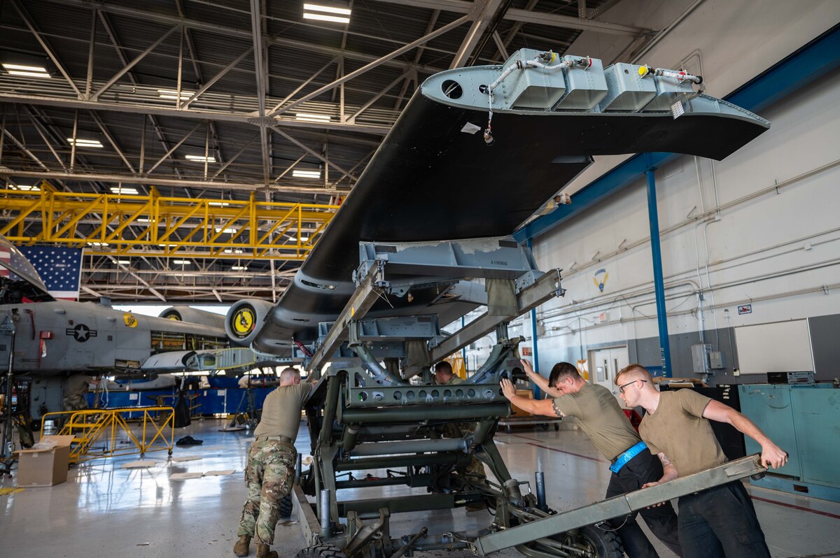 A photo of Airmen replacing an A-10 wing