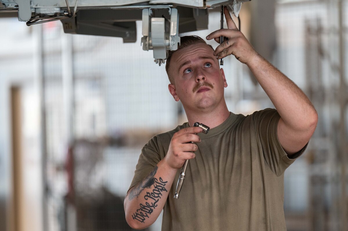 A photo of Airmen replacing an A-10 wing