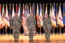 Soldiers at attention in front of flags