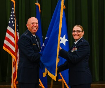 Brig. Gen. Lori Jones, Mobilization Assistant to the Director, Cyberspace Operations and Warfighter Communications in Washington D.C., accepts the brigadier general flag from retired Chaplain, Maj. Gen. Howard Stendahl during her promotion ceremony to brigadier general Oct. 16, 2022, at Joint Base San Antonio-Lackland, Texas. Jones was the first commander of the 960th Cyberspace Wing, the only cyberspace wing in the Air Force Reserve, activated on Nov. 18, 2018. (U.S. Air Force photo by Tech. Sgt. Michael Lahrman)