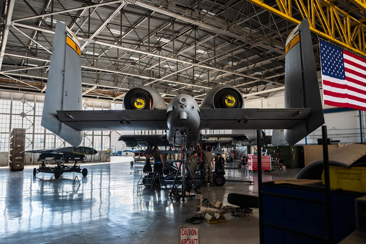 A photo of Airmen replacing an A-10 wing