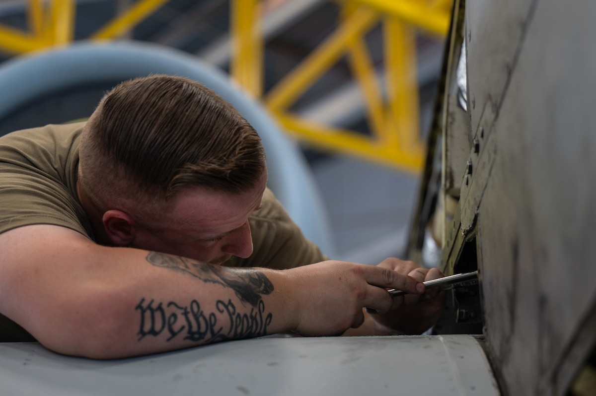 A photo of Airmen replacing an A-10 wing